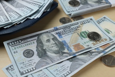 Photo of Dollar banknotes and coins on wooden table, closeup. Money exchange