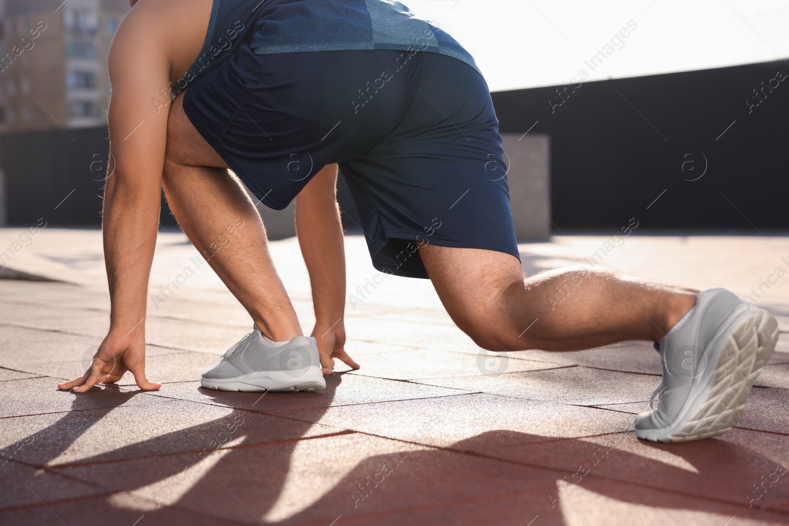 Photo of Runner on starting position outdoors on sunny day, closeup