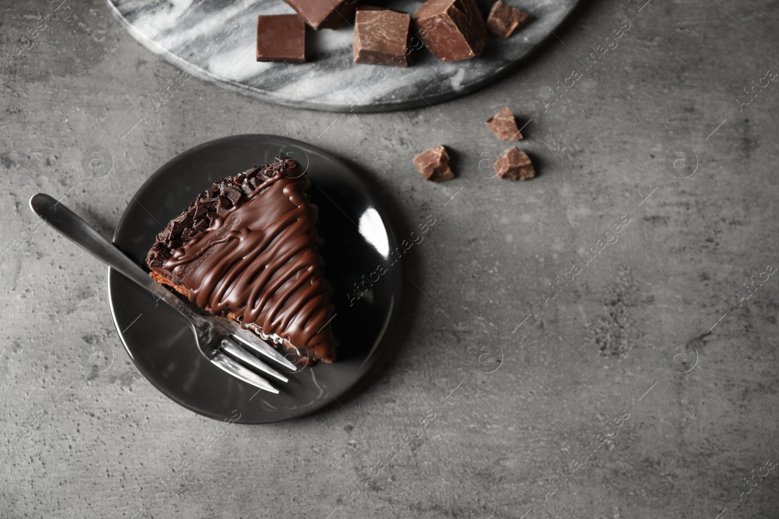 Photo of Tasty chocolate cake served on grey table, flat lay. Space for text