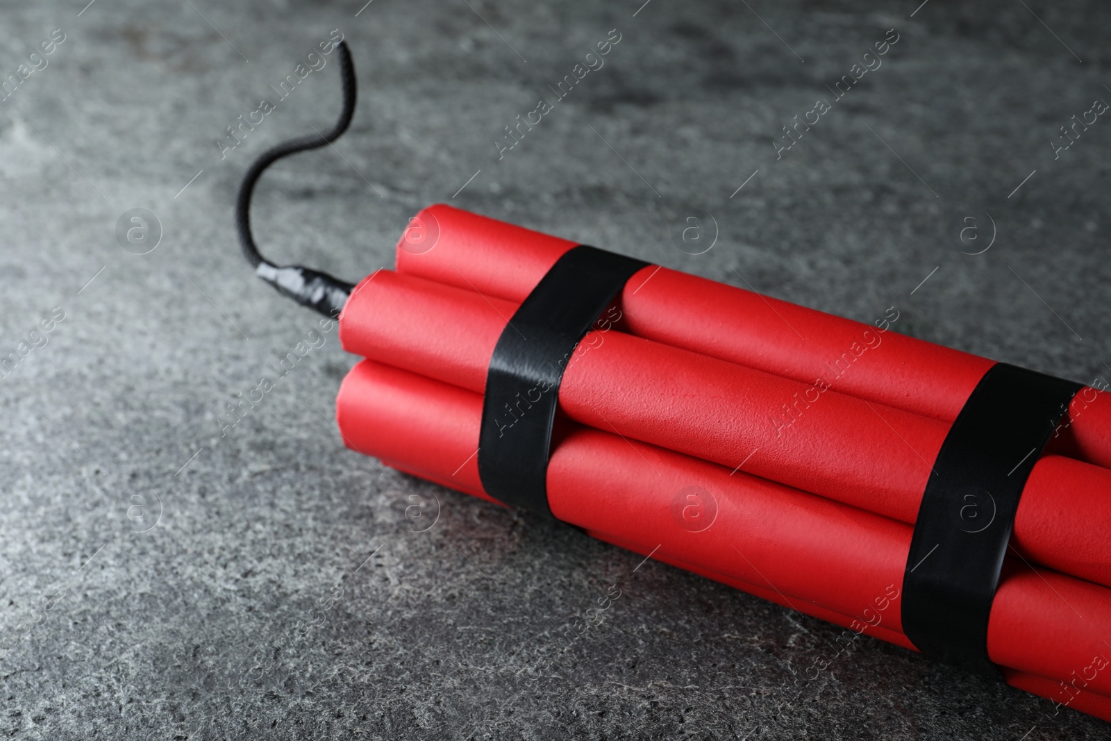 Photo of Red dynamite bomb on grey table, closeup