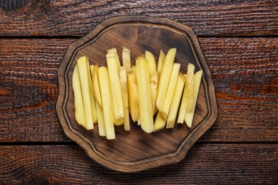 Photo of Cut raw potatoes on wooden table, top view