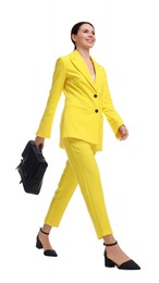 Photo of Beautiful businesswoman in yellow suit with briefcase walking on white background, low angle view