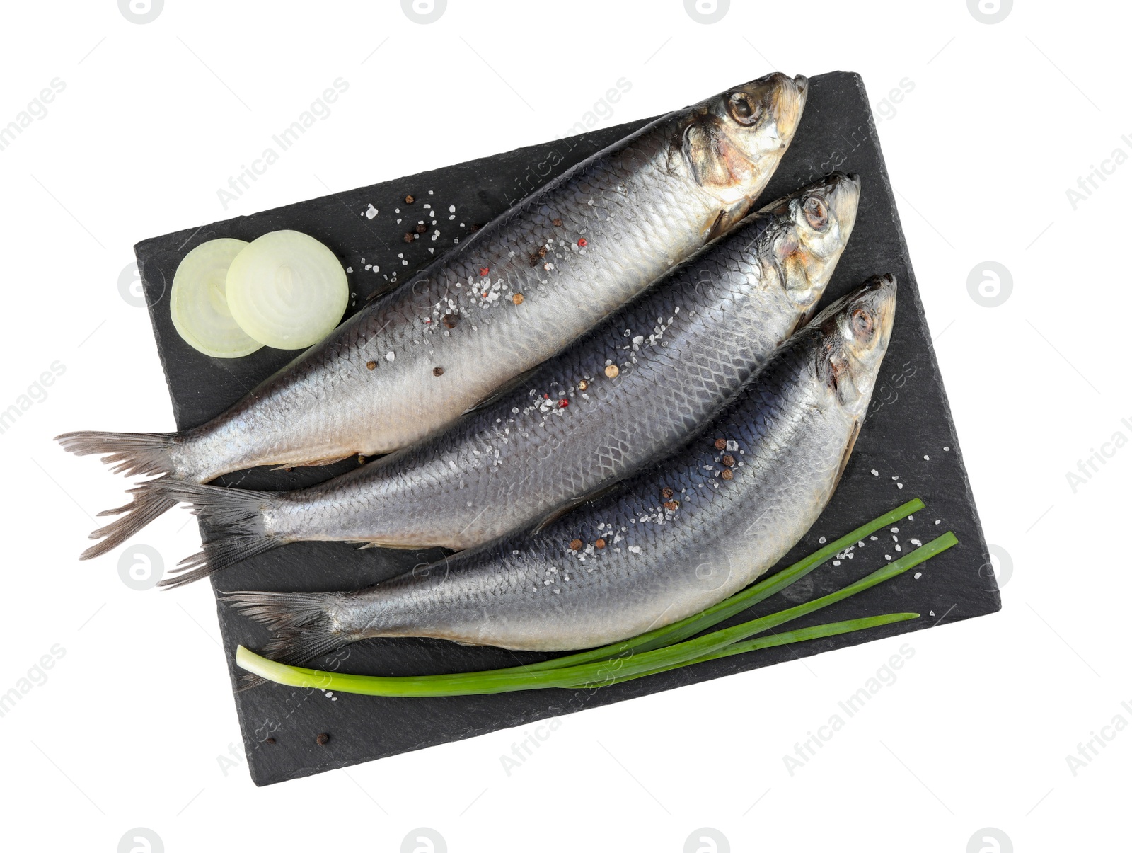 Photo of Slate plate with salted herrings, spices and onion isolated on white, top view