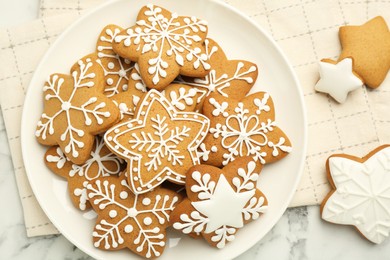 Tasty star shaped Christmas cookies with icing on white marble table, top view