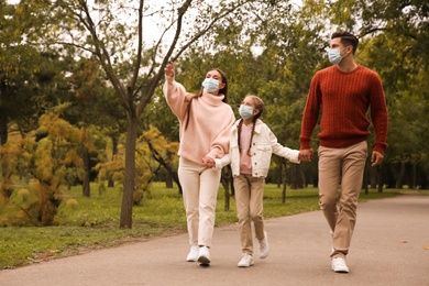 Photo of Lovely family walking together in park during coronavirus pandemic