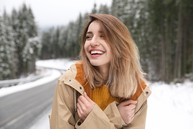 Young woman in warm clothes outdoors. Winter vacation