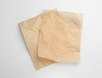 Photo of Sheets of brown baking paper on white background, top view