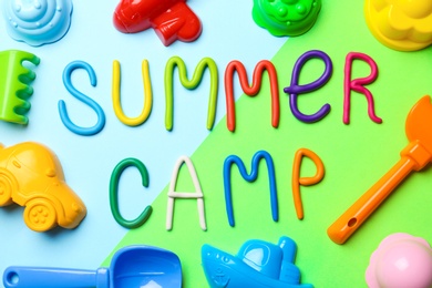 Photo of Text SUMMER CAMP made of modelling clay and different sand molds on color background, flat lay