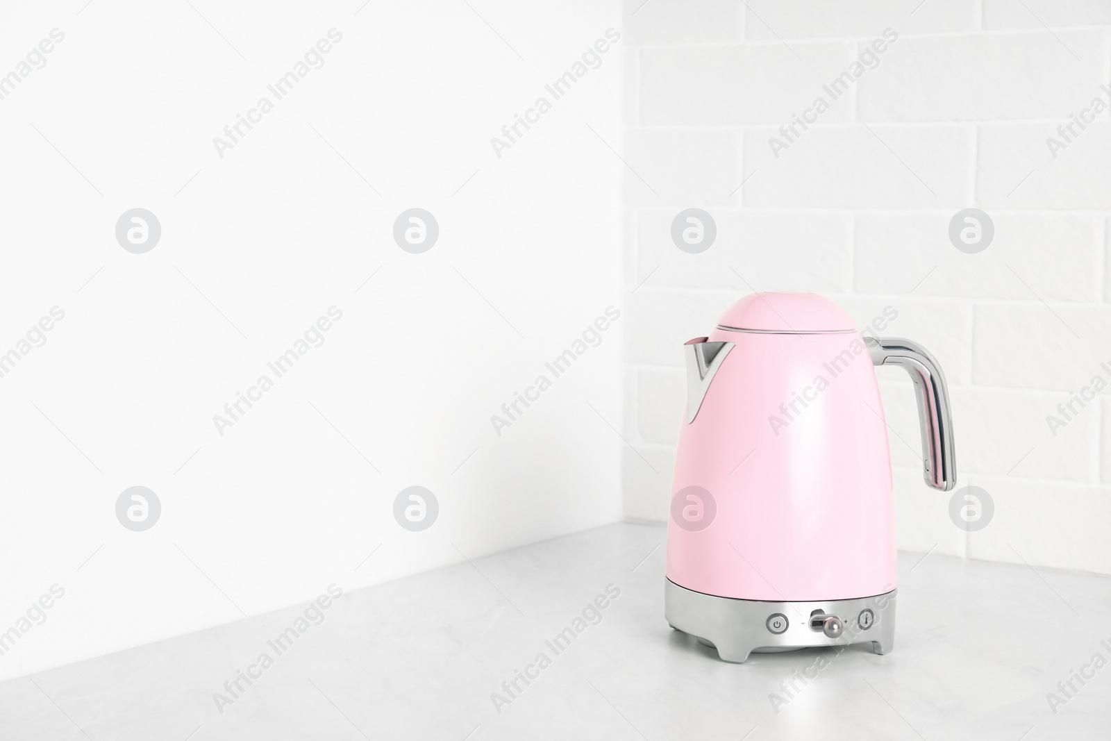 Photo of Modern electric kettle on counter in kitchen. Space for text