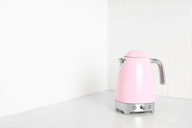 Modern electric kettle on counter in kitchen. Space for text