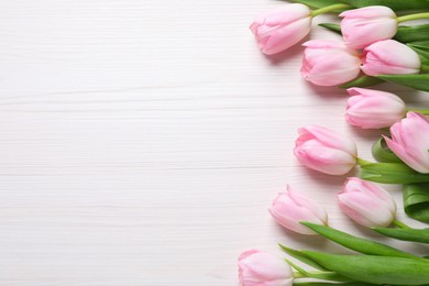 Beautiful pink spring tulips on white wooden background, flat lay. Space for text