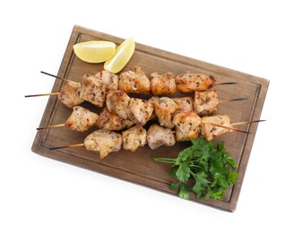 Photo of Wooden board with delicious fresh shish kebabs, parsley and lemon isolated on white, top view
