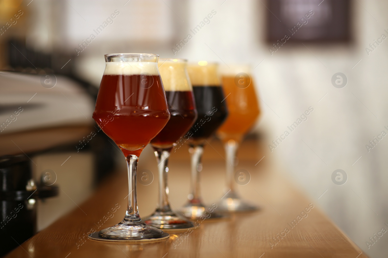 Photo of Different beers in glasses on bar counter