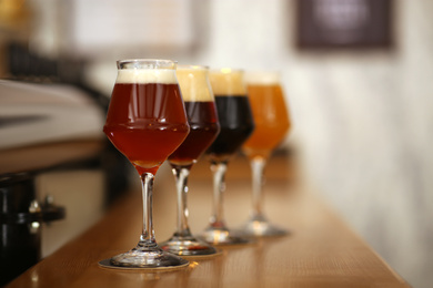 Different beers in glasses on bar counter