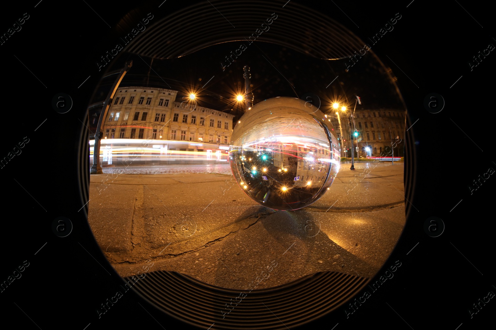 Photo of Crystal ball on asphalt road at night, wide-angle lens