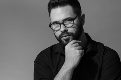 Photo of Portrait of handsome bearded man on grey background. Black and white effect