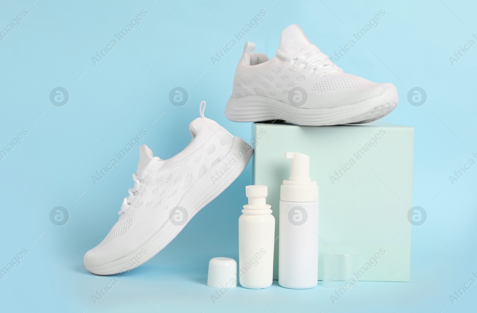 Photo of Composition with stylish footwear and shoe care accessories on light blue background