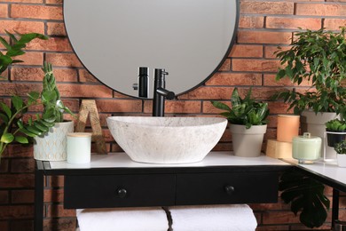 Photo of Stylish sink and beautiful green houseplants in bathroom. Interior design