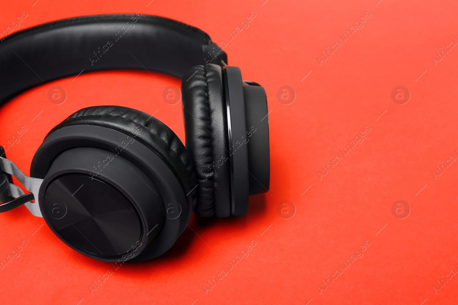 Photo of Stylish headphones on color background, closeup. Space for text