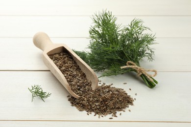 Photo of Dry seeds and fresh dill on white wooden table