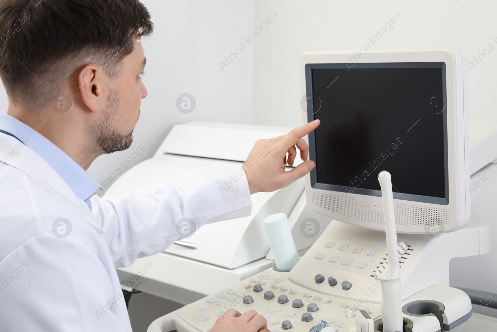 Photo of Professional sonographer using modern ultrasound machine in clinic