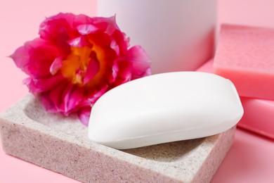 Photo of Dish with soap bar and flower on pink background, closeup