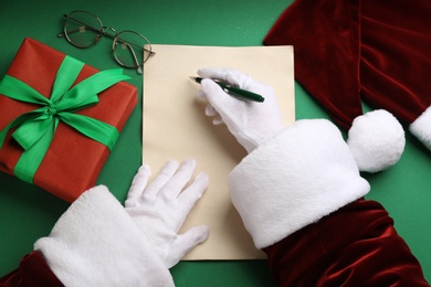 Photo of Top view of Santa writing letter at green table, closeup