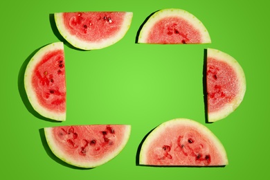 Photo of Frame of watermelon slices on green background, flat lay. Space for text