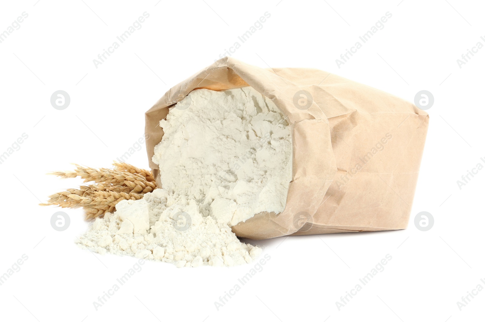 Photo of Overturned paper bag of flour and spikelets isolated on white