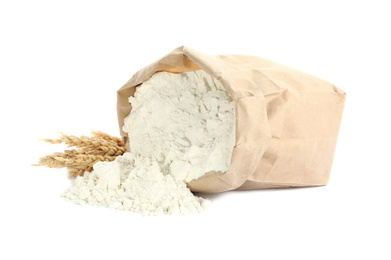 Overturned paper bag of flour and spikelets isolated on white