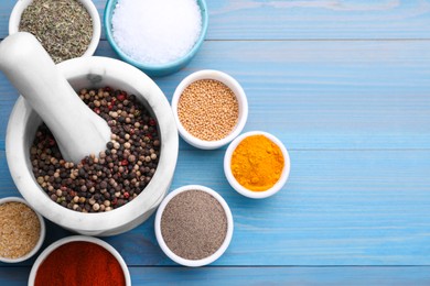 Photo of Flat lay composition with mortar and different spices on light blue wooden table, space for text