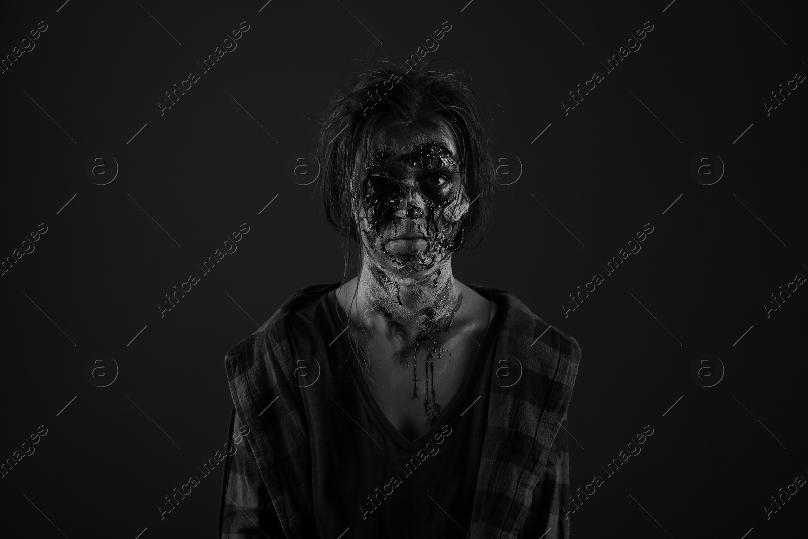 Photo of Scary zombie on dark background, black and white effect. Halloween monster