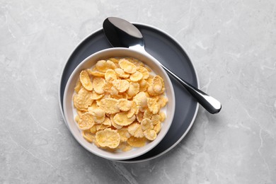 Photo of Tasty cornflakes with milk served on light grey table, top view