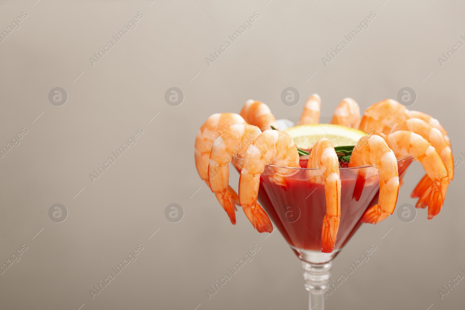 Photo of Shrimp cocktail with tomato sauce on light grey background. Space for text