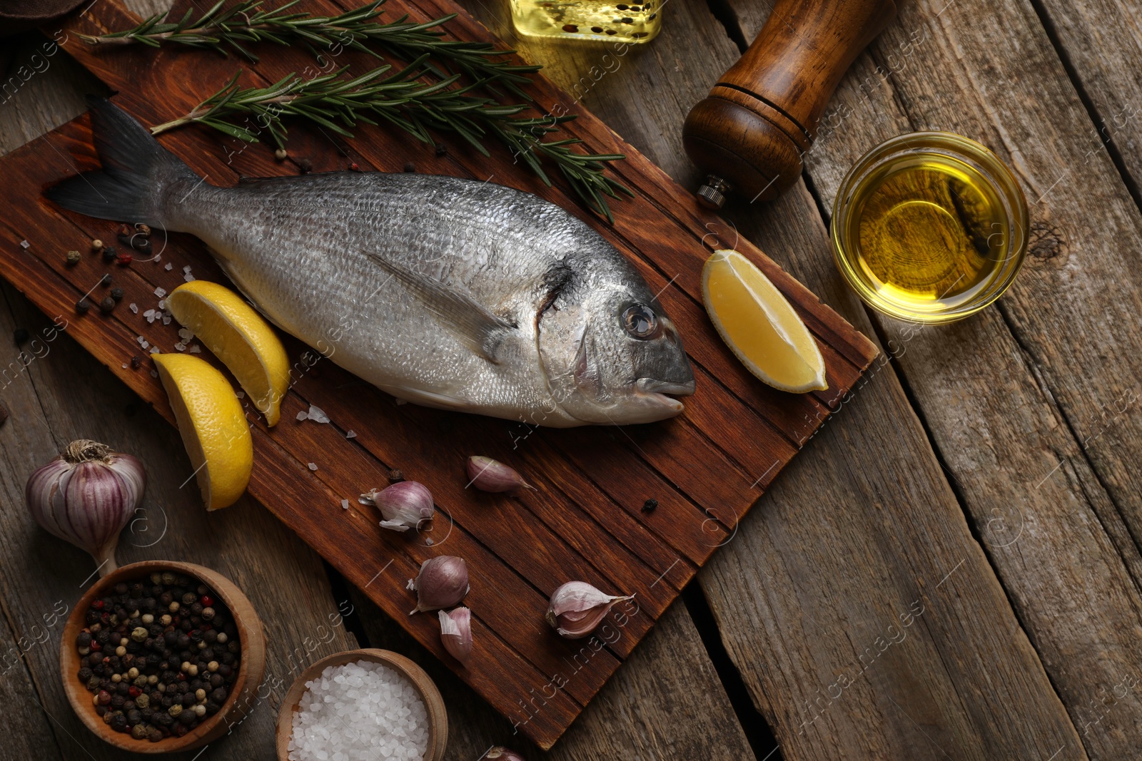 Photo of Flat lay composition with raw dorado fish and spices on wooden table. Space for text