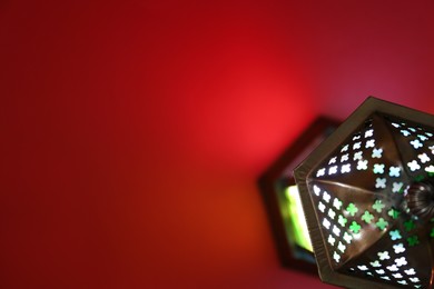 Decorative Arabic lantern on red background, top view. Space for text