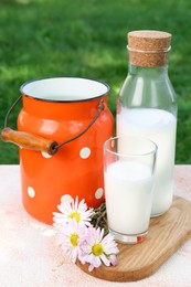 Photo of Tasty fresh milk on color textured table outdoors