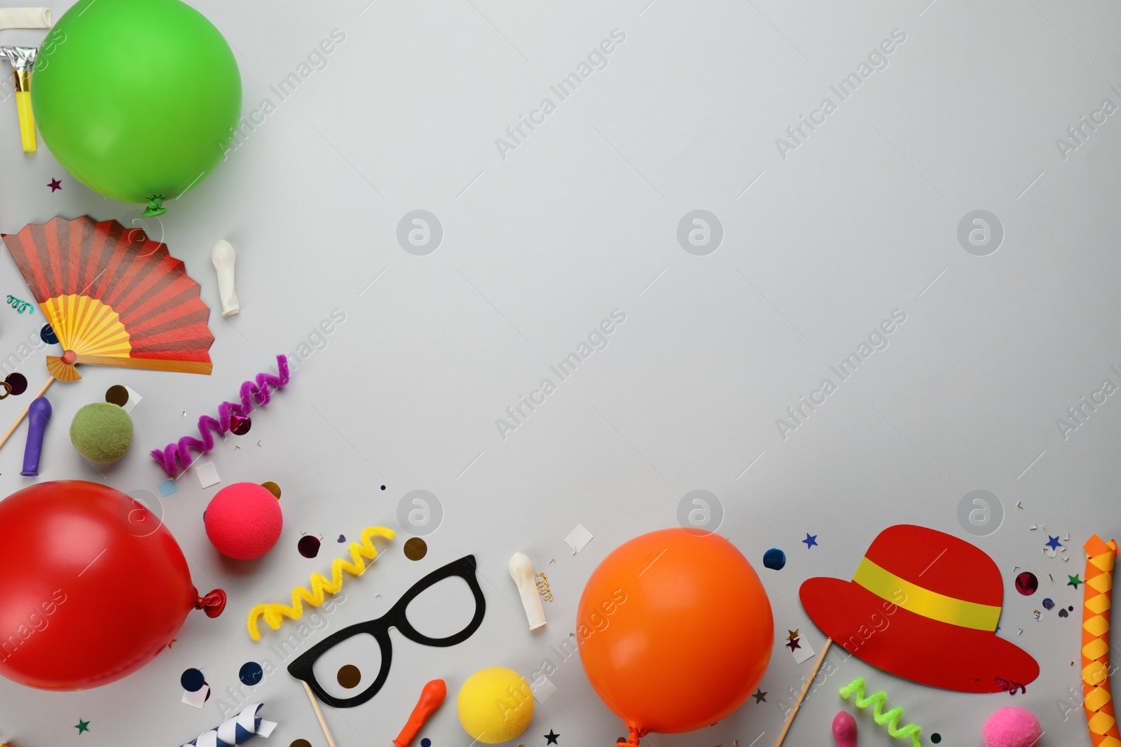 Photo of Flat lay composition with carnival items on light grey background. Space for text