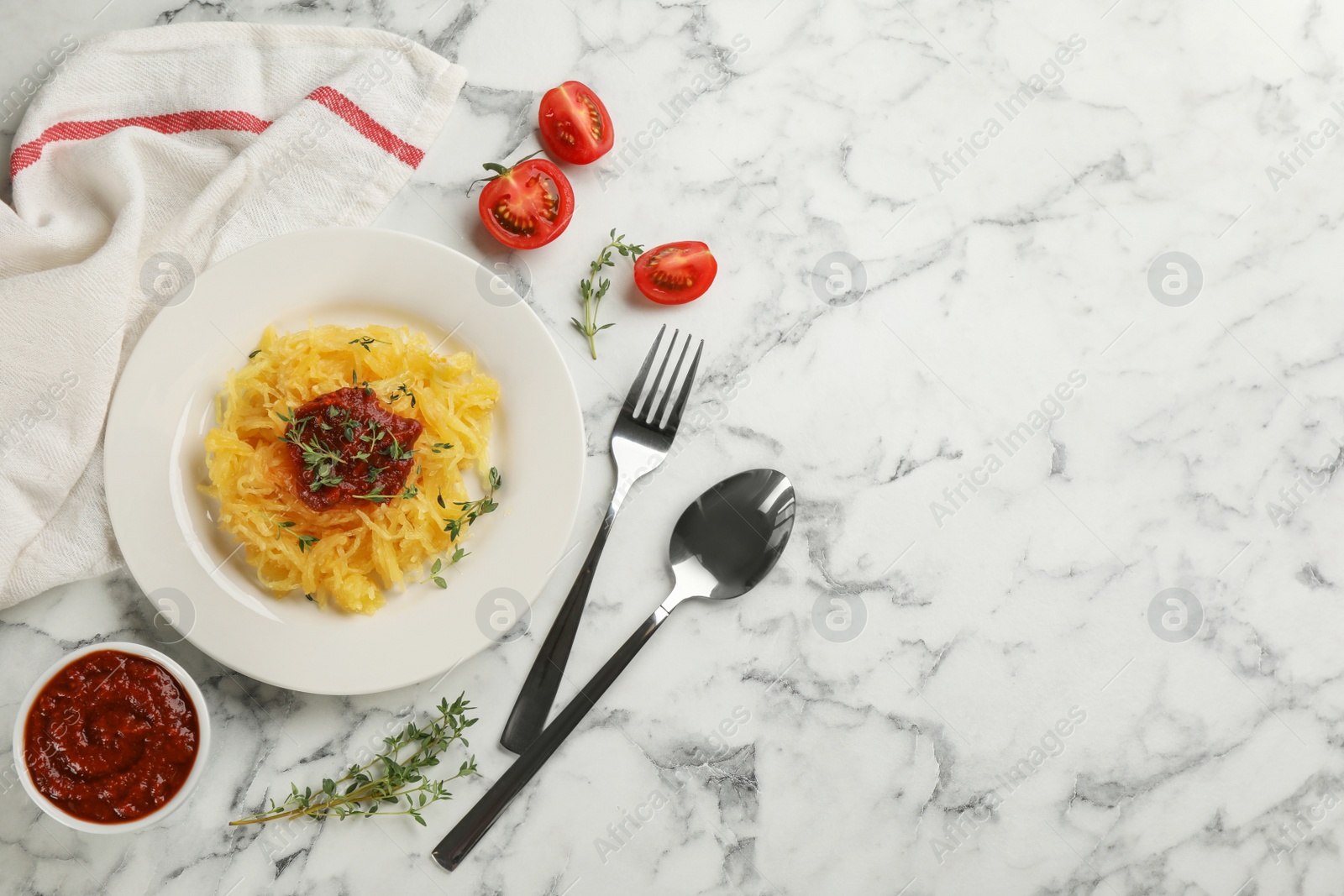 Photo of Tasty spaghetti squash with thyme and tomato sauce served on white marble table, flat lay. Space for text