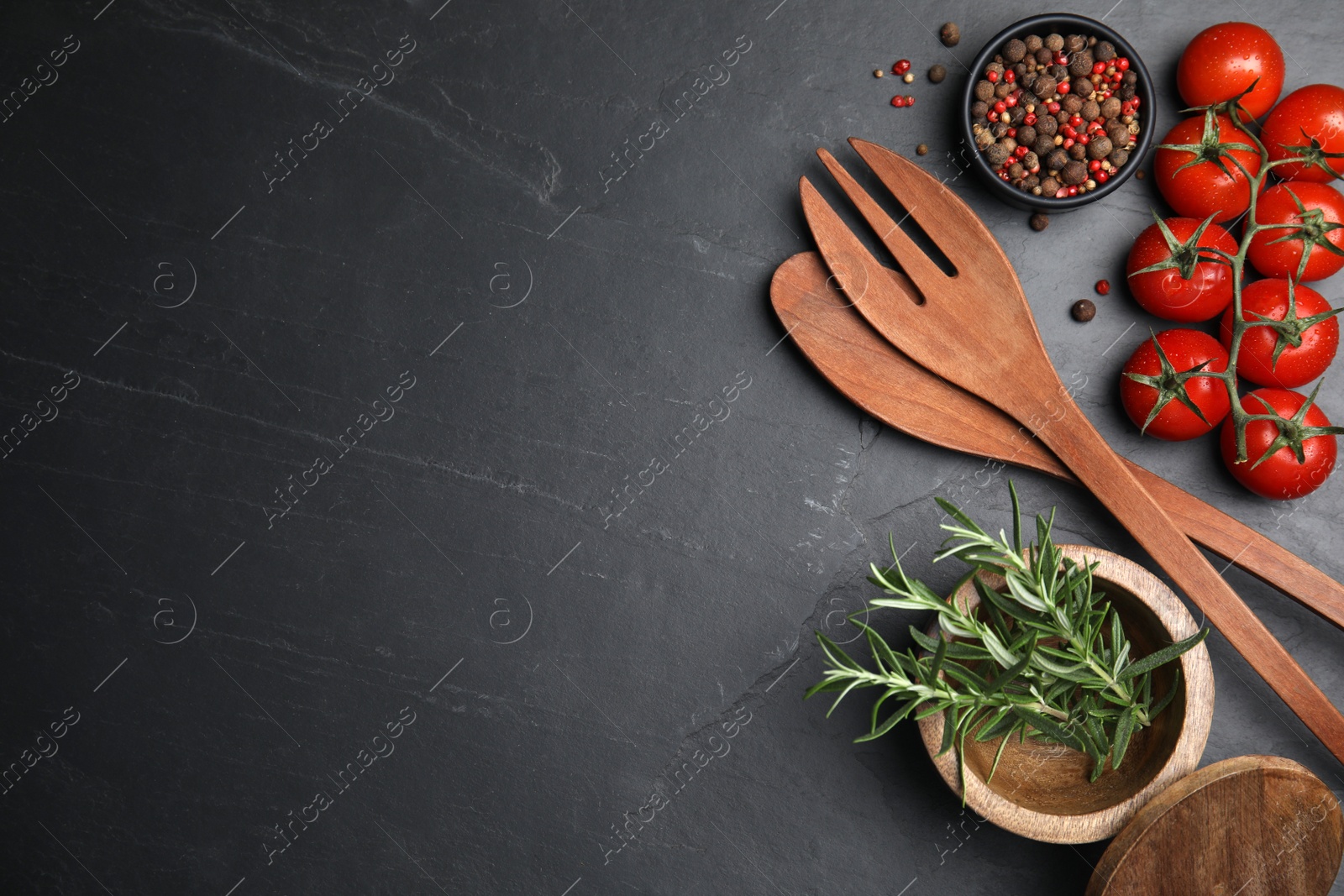 Photo of Flat lay composition with wooden cooking utensils on black table. Space for text