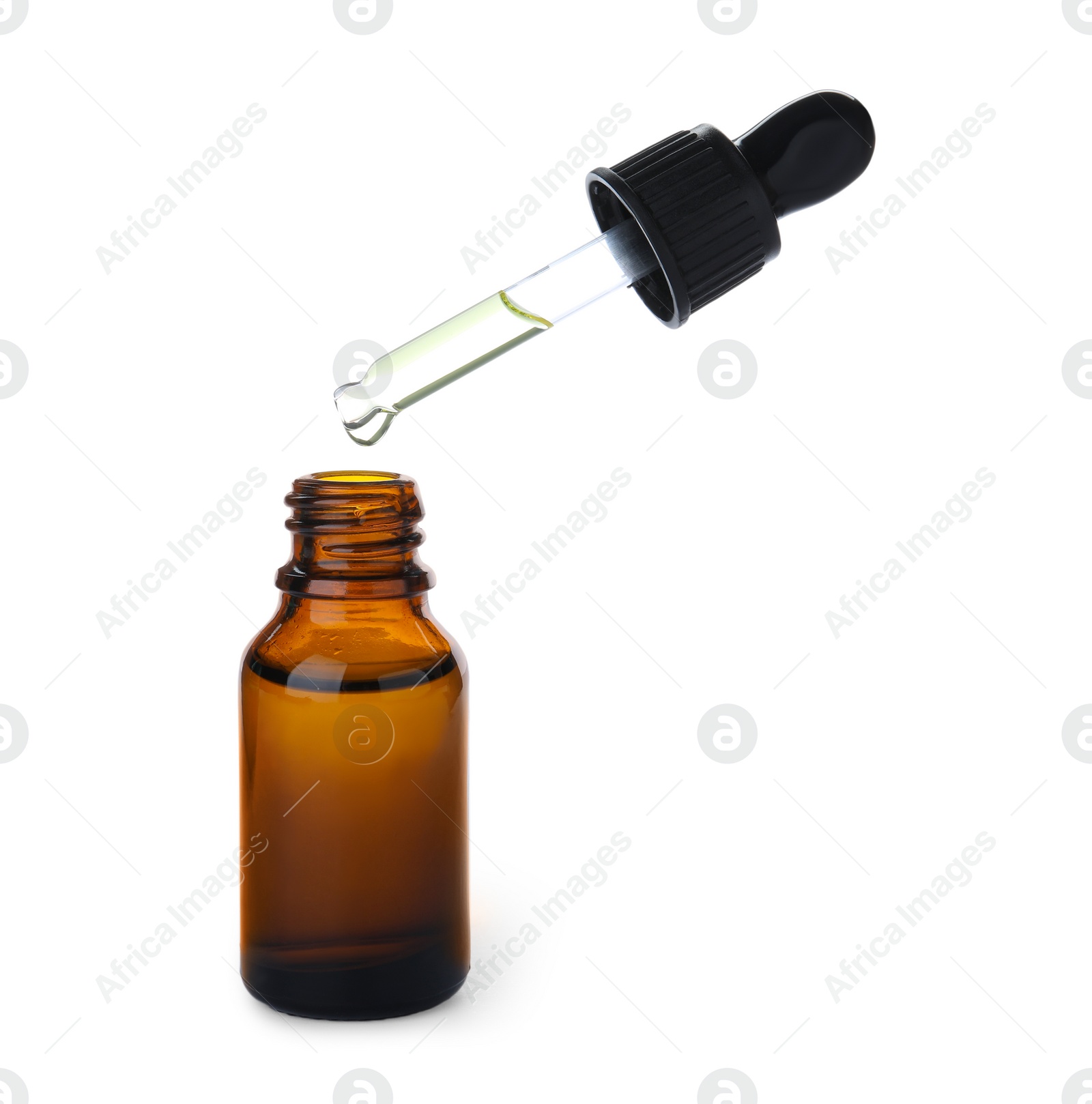 Photo of Dripping essential oil from pipette into bottle isolated on white