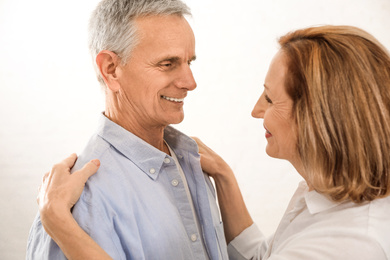 Photo of Happy senior couple dancing together on light background