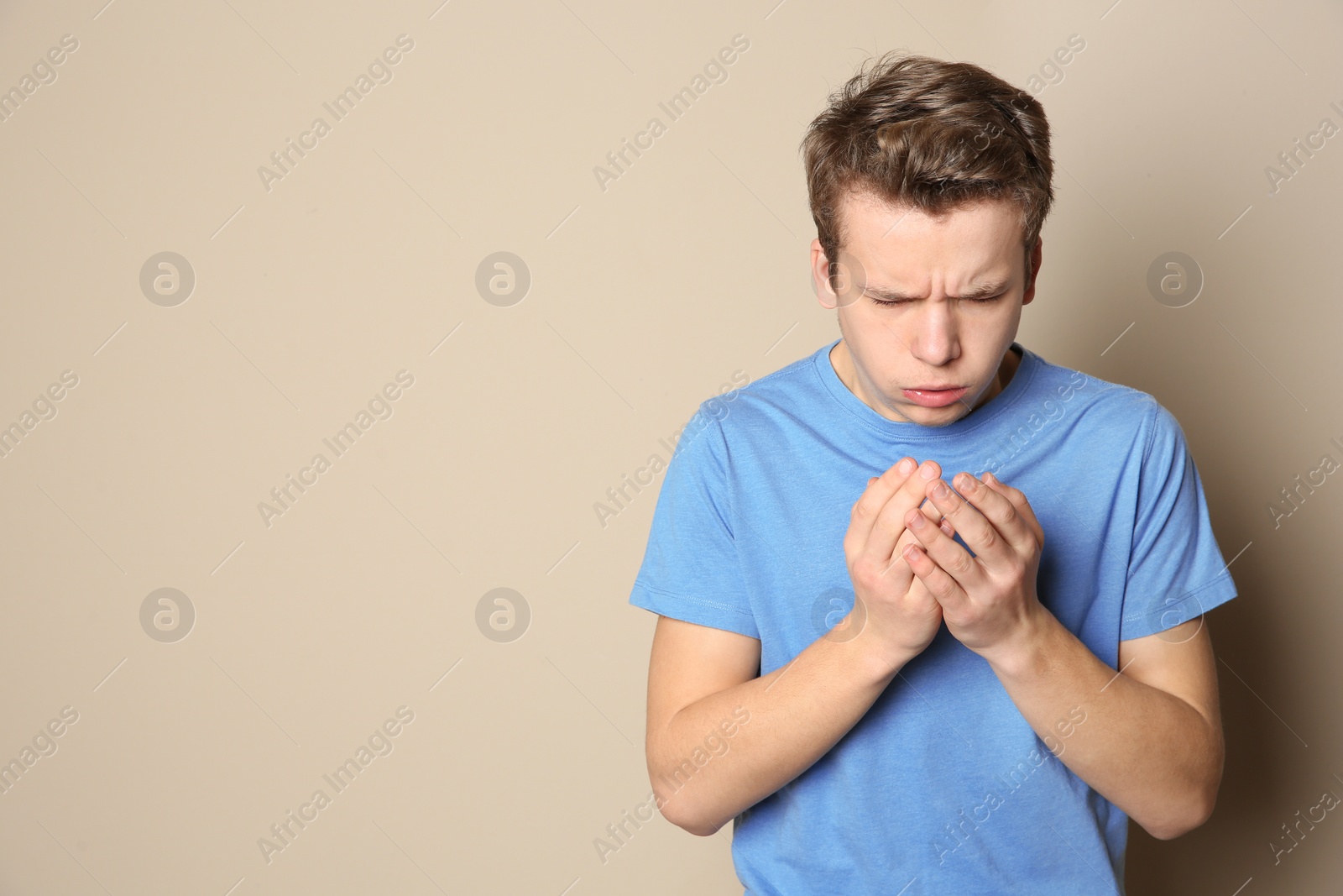 Photo of Teenage boy suffering from cough on color background. Space for text