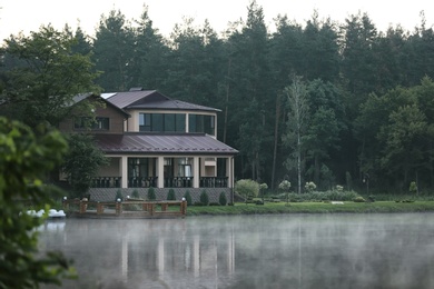 Beautiful landscape with forest and house near lake. Summer camp location