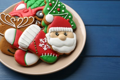 Photo of Different tasty Christmas cookies on blue wooden table, above view. Space for text