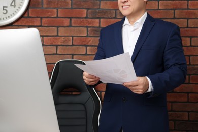 Boss holding document in office, closeup view