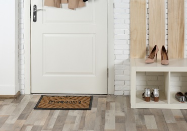 Hallway interior with shoe rack and mat near door