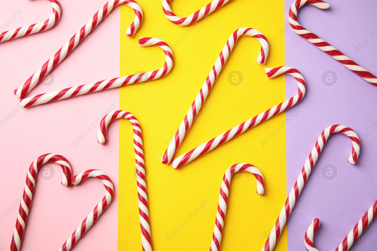 Photo of Flat lay composition with candy canes on color background