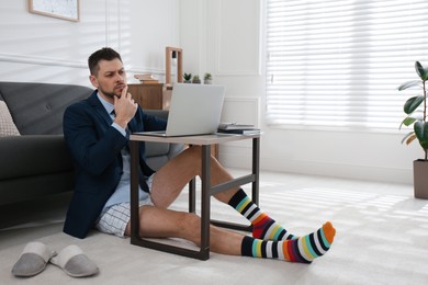 Photo of Businessman in underwear pretending to wear formal clothes during video call at home
