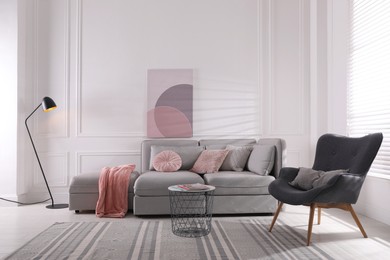 Photo of Cozy living room interior with comfortable grey sofa and armchair